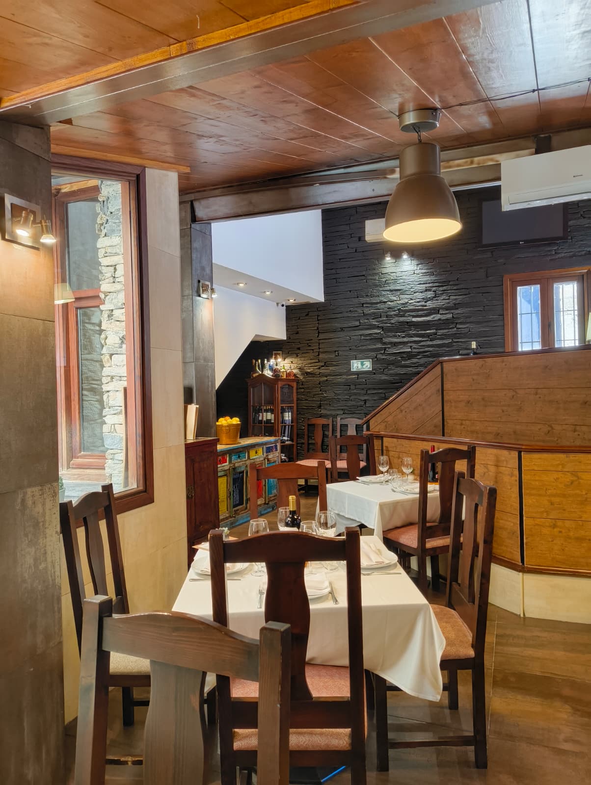 Comedor principal del restaurante El Rincón de Patones con pizarra y madera